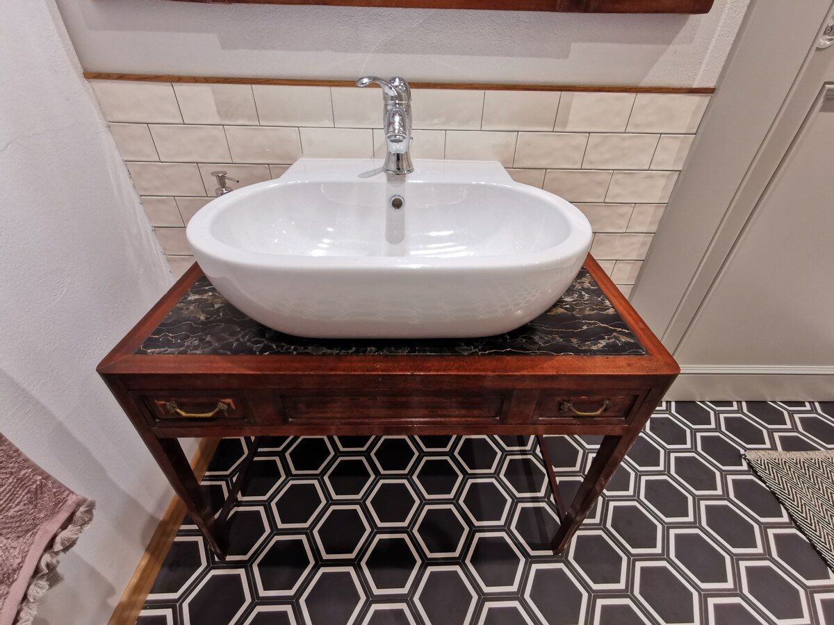 A bathroom with stone-toned tiles