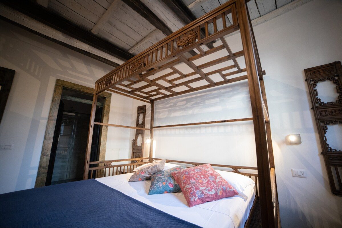 Wooden canopy bed under old beams