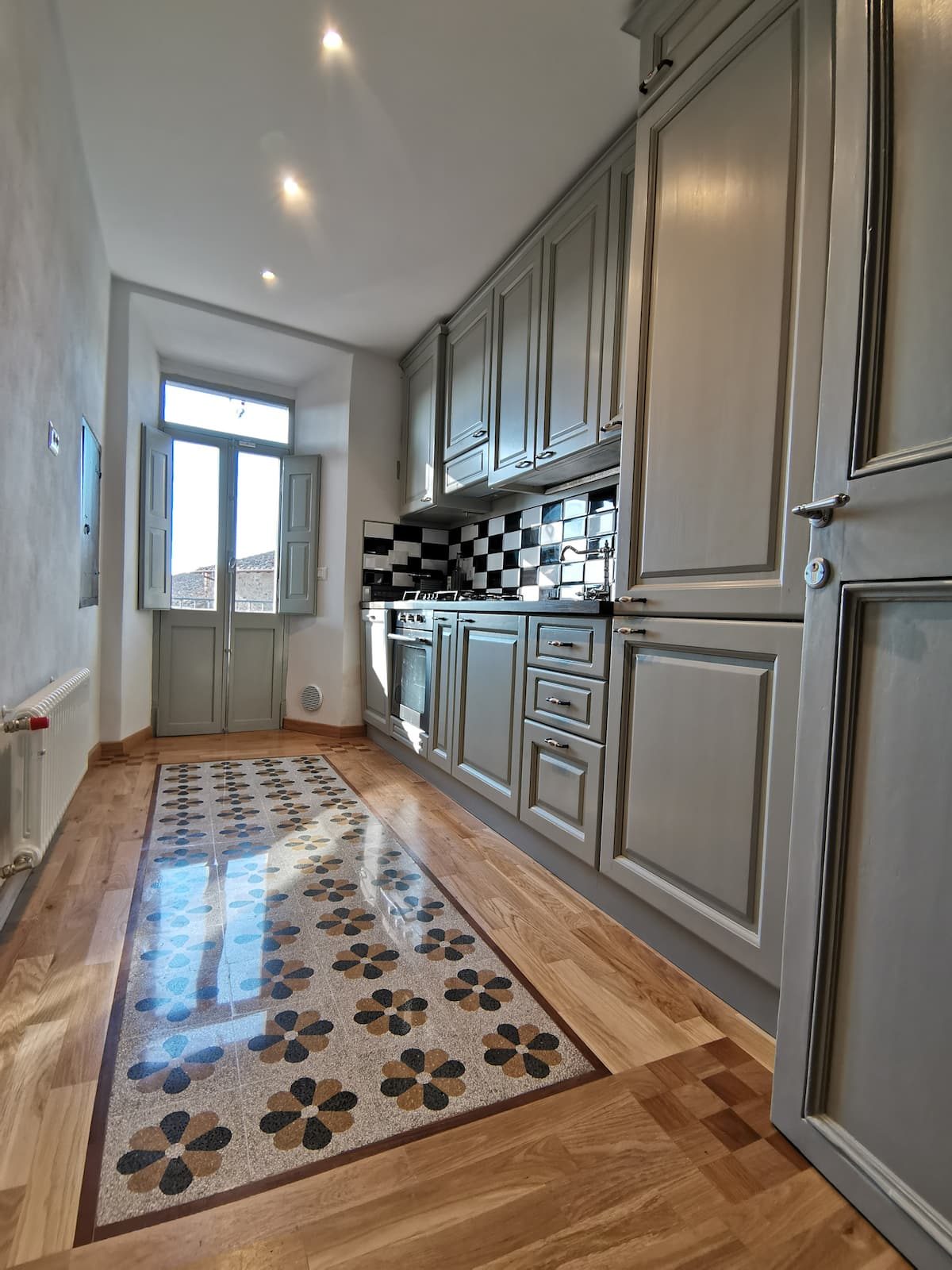 Sage-grey kitchen cabinets and terrazzo floor