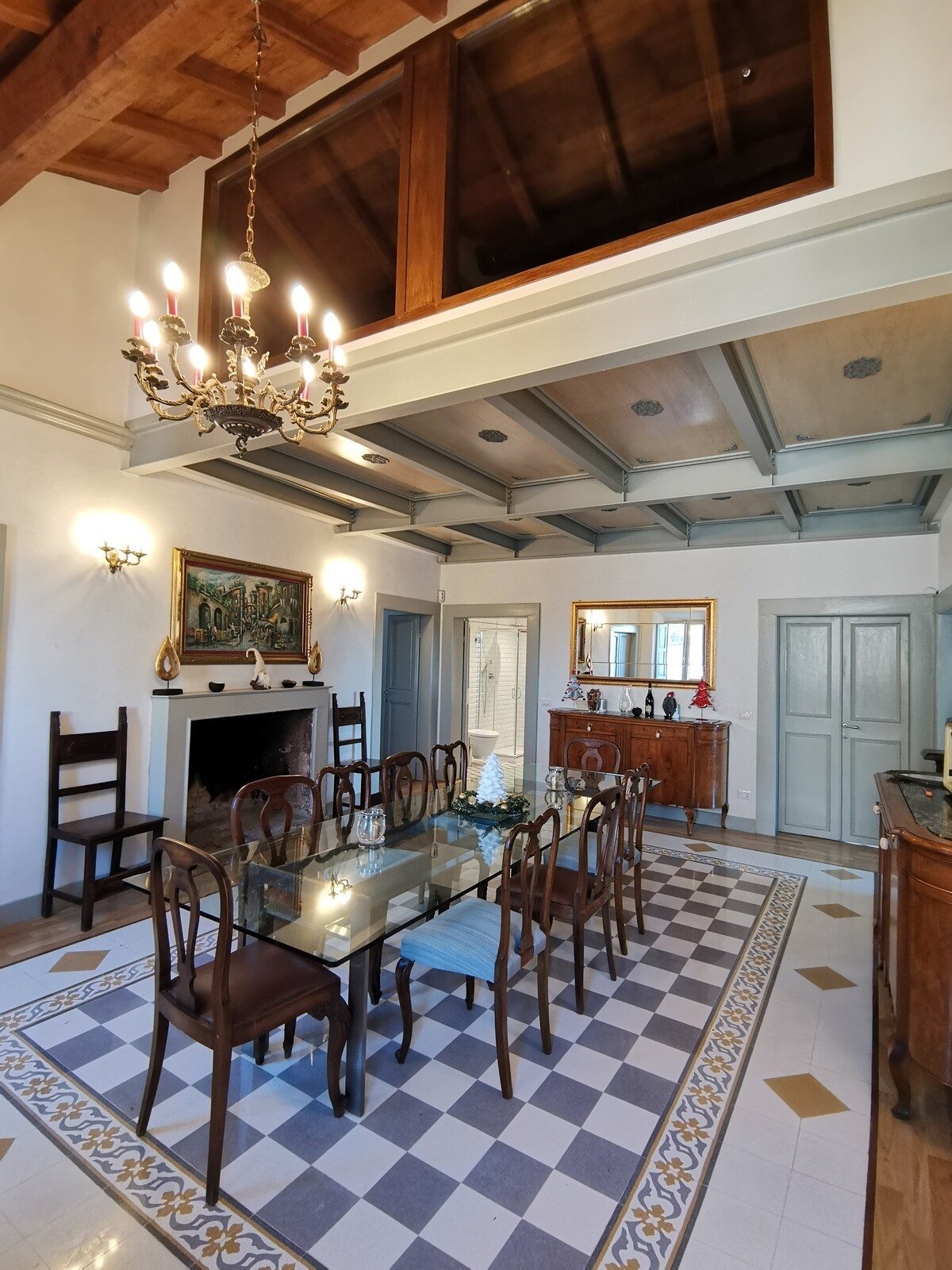 The dining room with chandelier and chequered floor