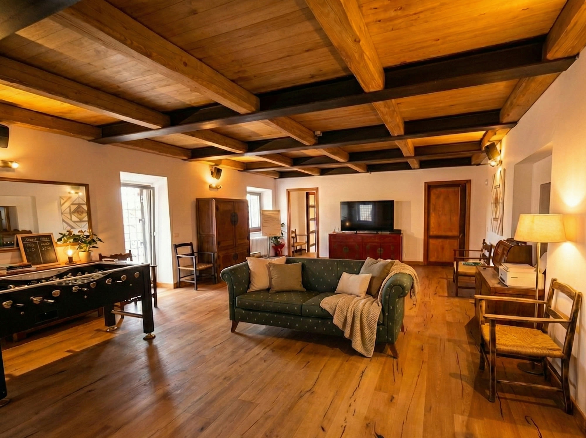 The main salon with beamed ceiling and green sofa