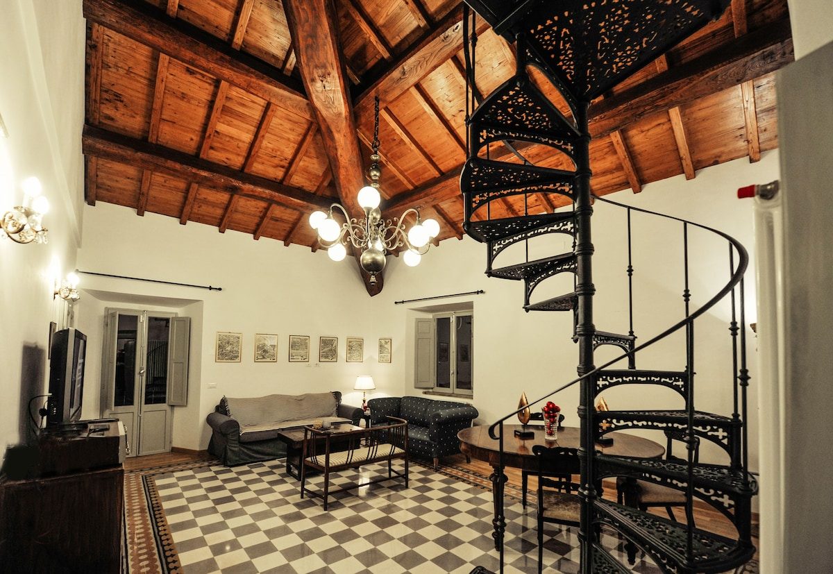 The main salon with its wrought-iron spiral staircase and chequered floor