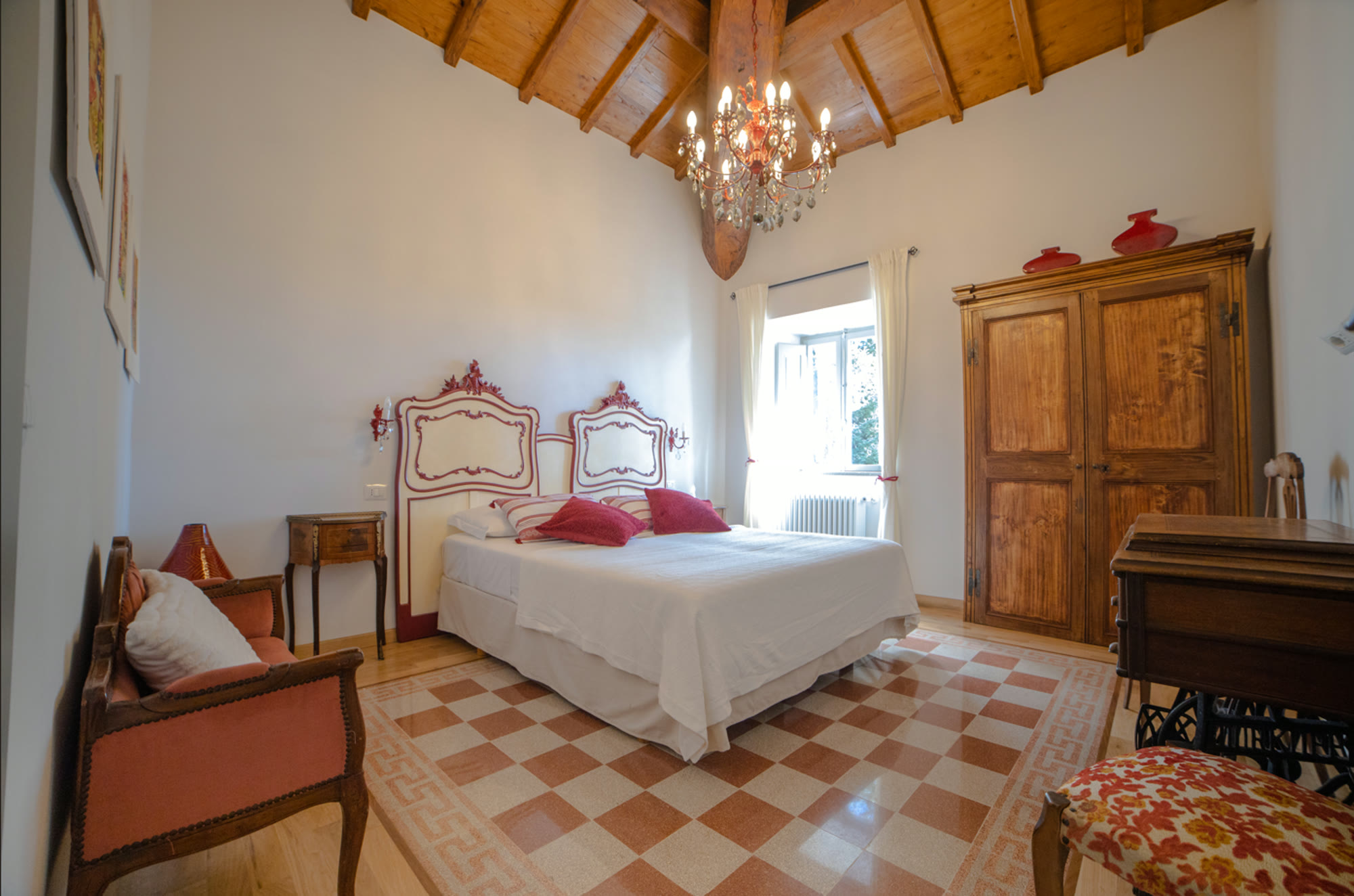 Bright room with carved headboards and chandelier